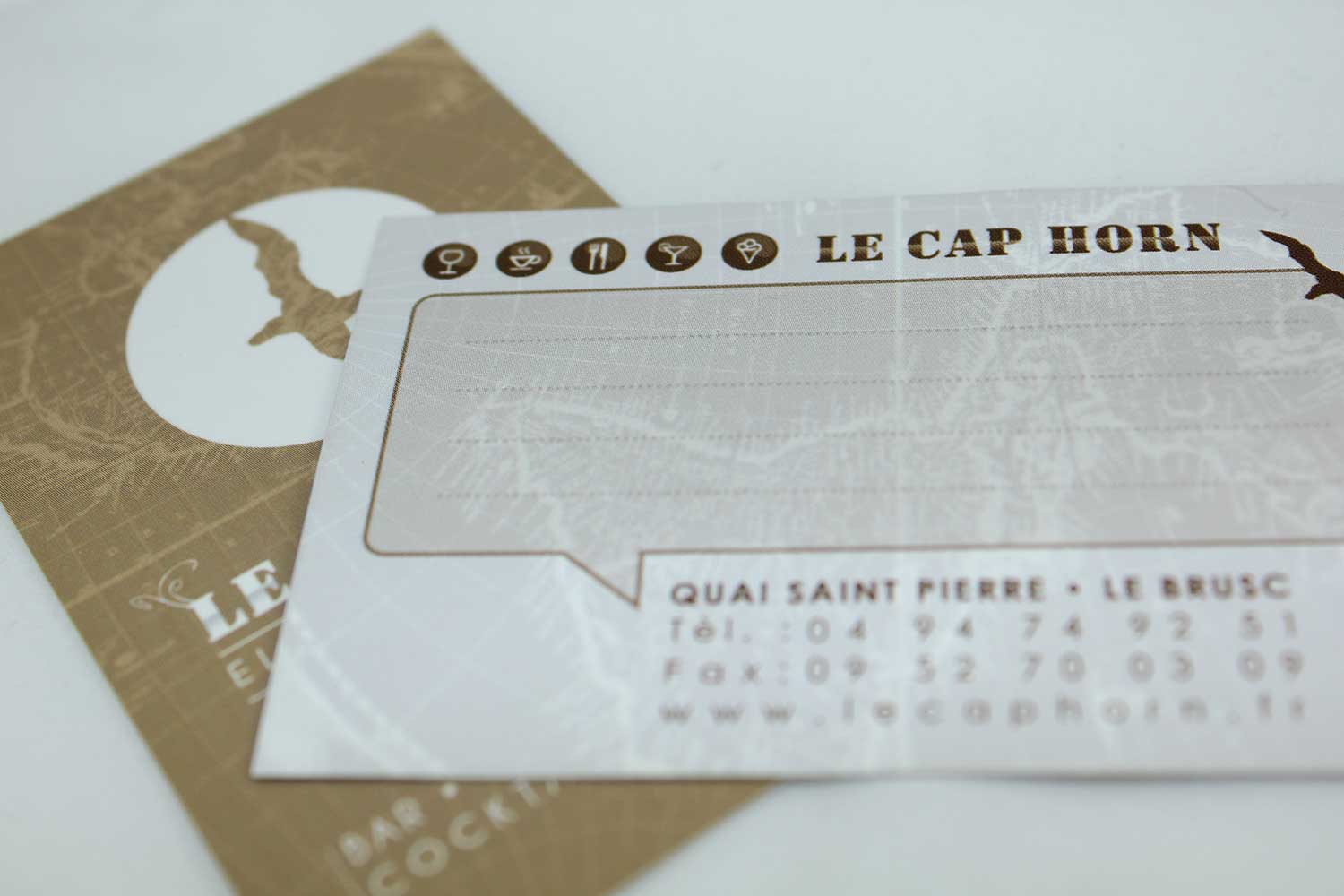 Verso de la carte de visite Le Cap Horn avec pictogrammes et coordonnées au Brusc