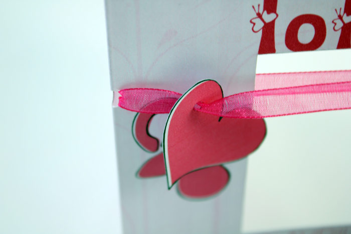 Détail du cœur en relief et du ruban satiné du faire-part Lola
